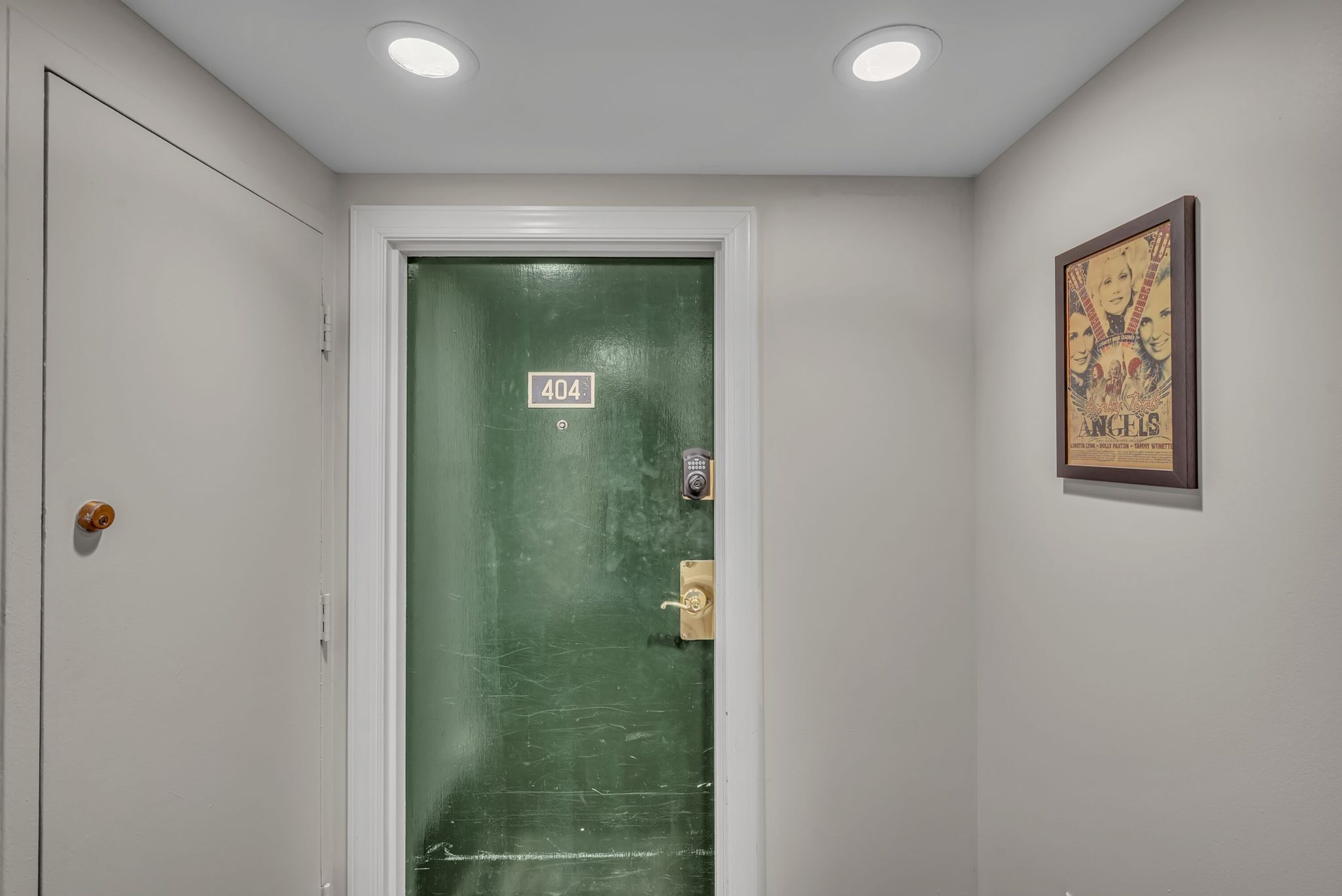 A door with a sign reading "404" and a poster of 'Angels' on the wall.