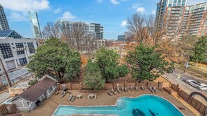 A residential area with a swimming pool, trees, and modern buildings in the background. - Honky Tonk Angels Suite (Nashville)