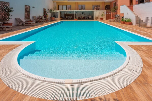 Piscina rectangular interior con un deck de madera alrededor.