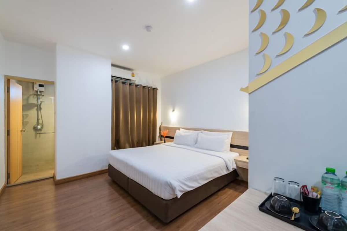 Ein Hotelzimmer mit einem Bett, einem Nachttisch und einem Tablett mit Toilettenartikeln.