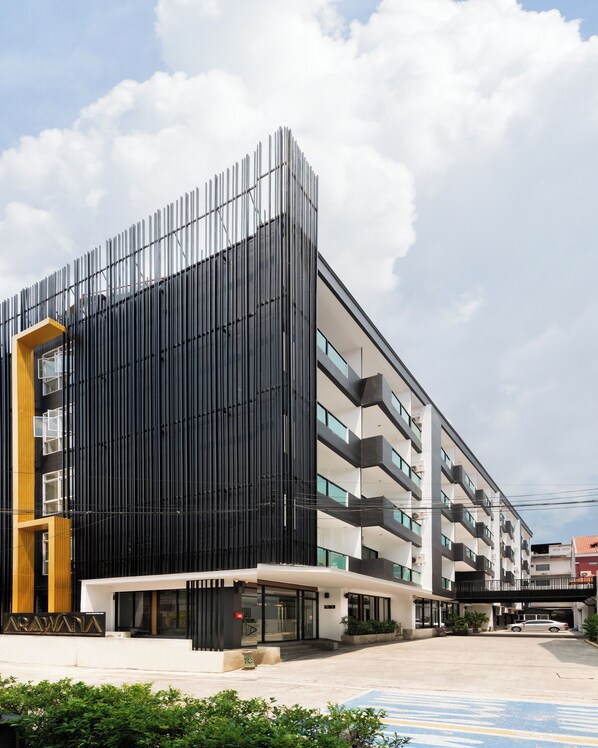 A modern building with a black facade, multiple floors, and a flat roof.