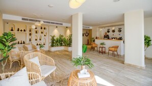 A hotel lobby with wicker furniture, a reception desk, and a variety of decorative items on the walls. - La Boutique Hôtel - Vue Des Pyramides (Giza)