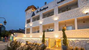 A hotel with a stone facade, multiple balconies, and potted plants in the foreground. - La Boutique Hôtel - Vue Des Pyramides (Giza)