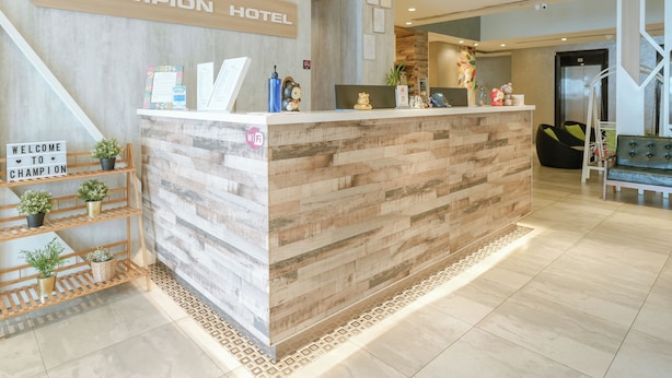 A reception desk with a wooden finish, a sign reading "CHAMPION HOTEL", and a "WELCOME TO CHAMPION" sign. - A Hotel Joo Chiat Stay from 7PM to 9AM (Singapore)