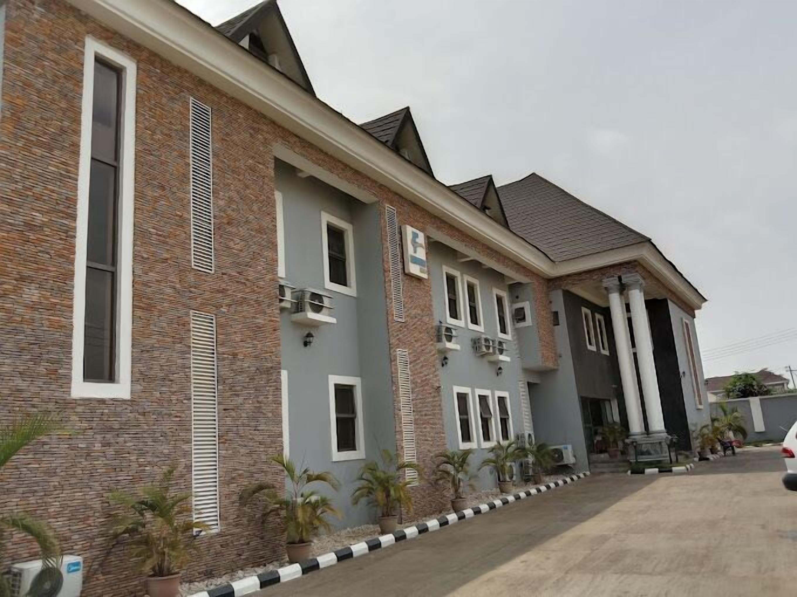 A multi-story building with a brick facade, multiple windows, and air conditioning units.
