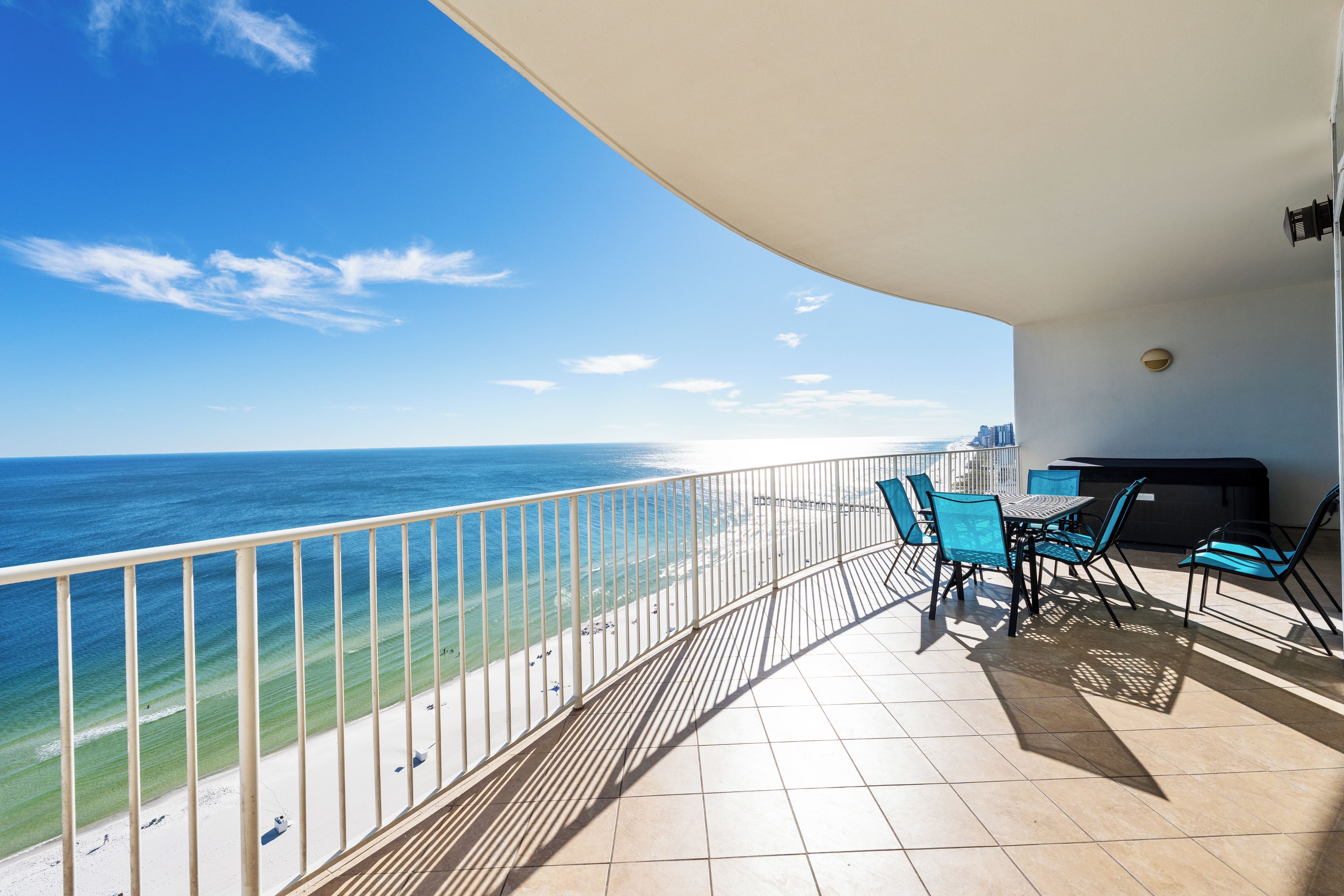 Een balkon met uitzicht op zee, een tafel met stoelen en een barbecue.