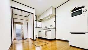 A modern kitchen with white cabinets, a microwave, and a built-in oven. - 10 min. drive to Osaka Castle 3DK rental spacious house / capacity for 9 people (osakashi,higashinariku,kamiji)