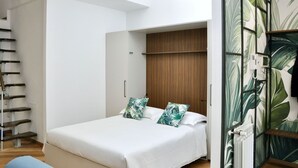 Un dormitorio con una cama, un armario de madera, techo blanco y una pared cubierta de plantas.