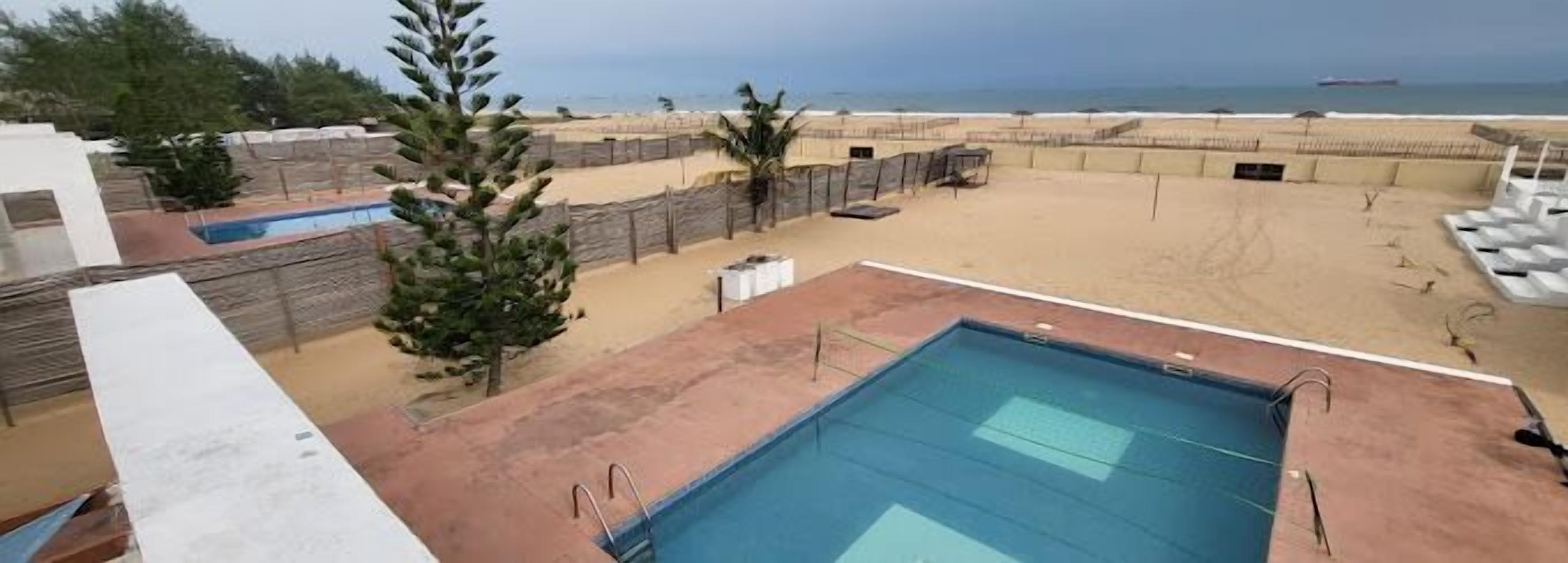 A rooftop pool with a view of the beach and ocean.