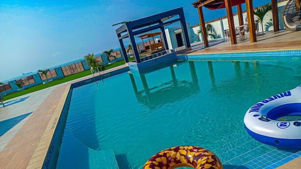 A swimming pool with a clear blue water surface, surrounded by a tiled deck. - Pura Vida Beach (Lagos)