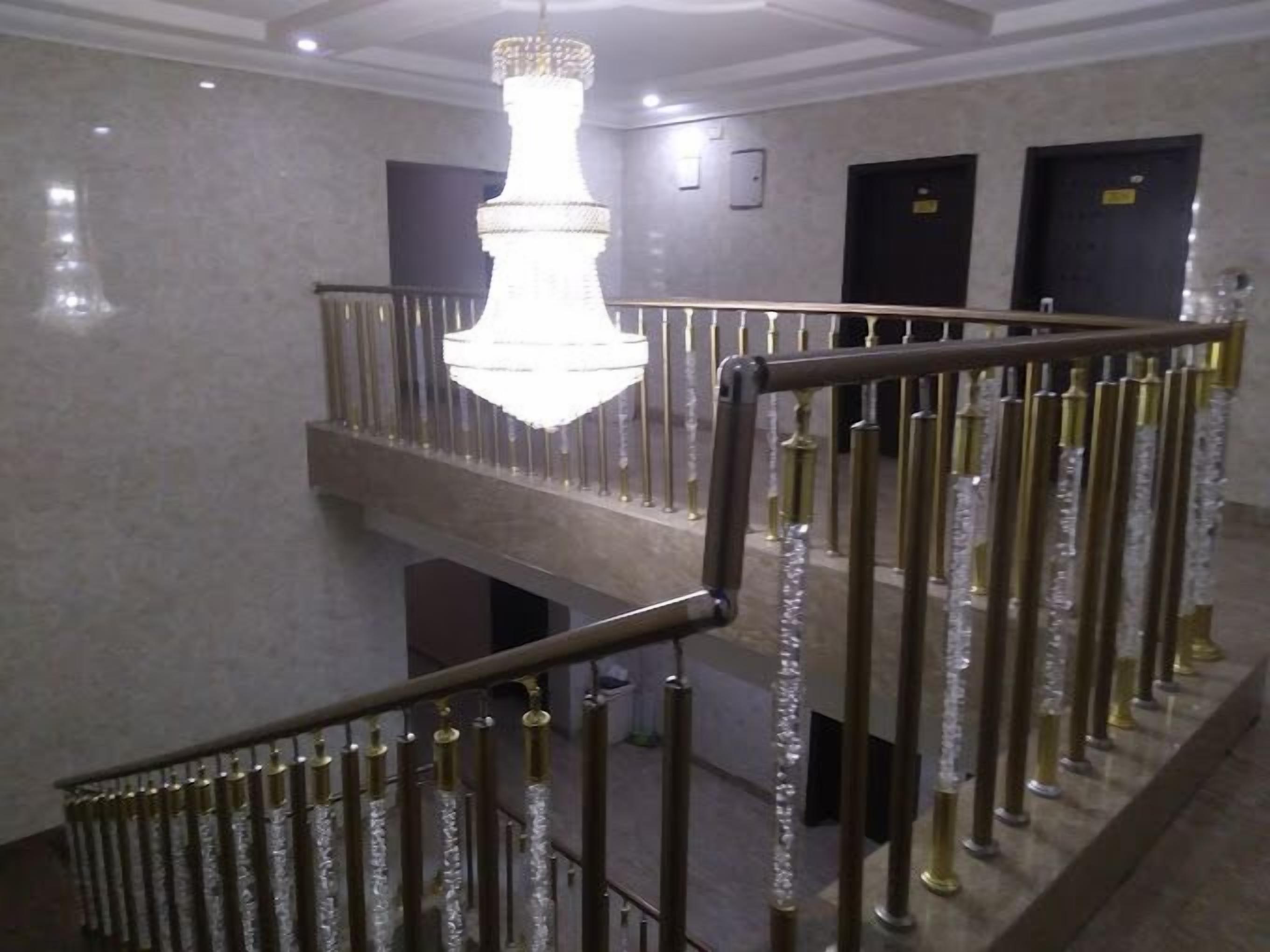 Una escalera con candelabro y barandales de metal.