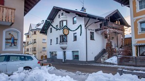 Un hotel con balcón, un letrero que dice "Salleur" y una calle cubierta de nieve.