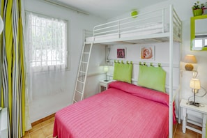 A bunk bed room with a ladder, a desk with a lamp, and a window with curtains. - House in Rosas With Waterfront & Beach Nearby (Roses)