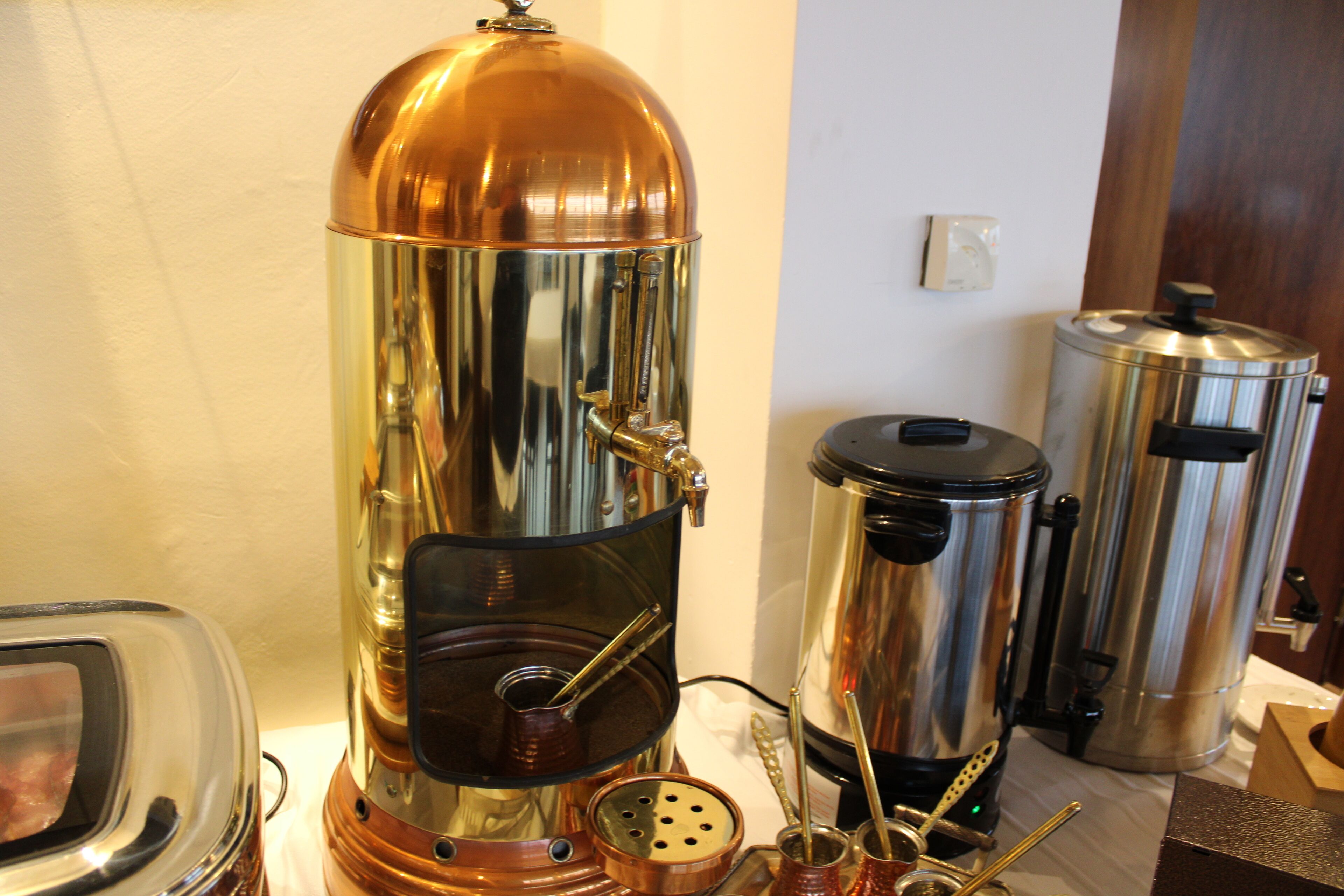 Eine Kaffeemaschine mit transparentem Wasserbehälter und einer Metall-Auffangschale.