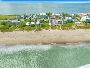 An aerial view of a coastal area with a beach, buildings, and a body of water. - Waterfront | Fishing Pier | Walk to Beach (Cocoa Beach)