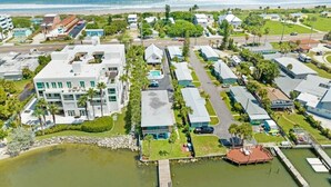 A coastal residential area with modern houses, a marina, and a beach in the background. - Waterfront | Fishing Pier | Walk to Beach (Cocoa Beach)