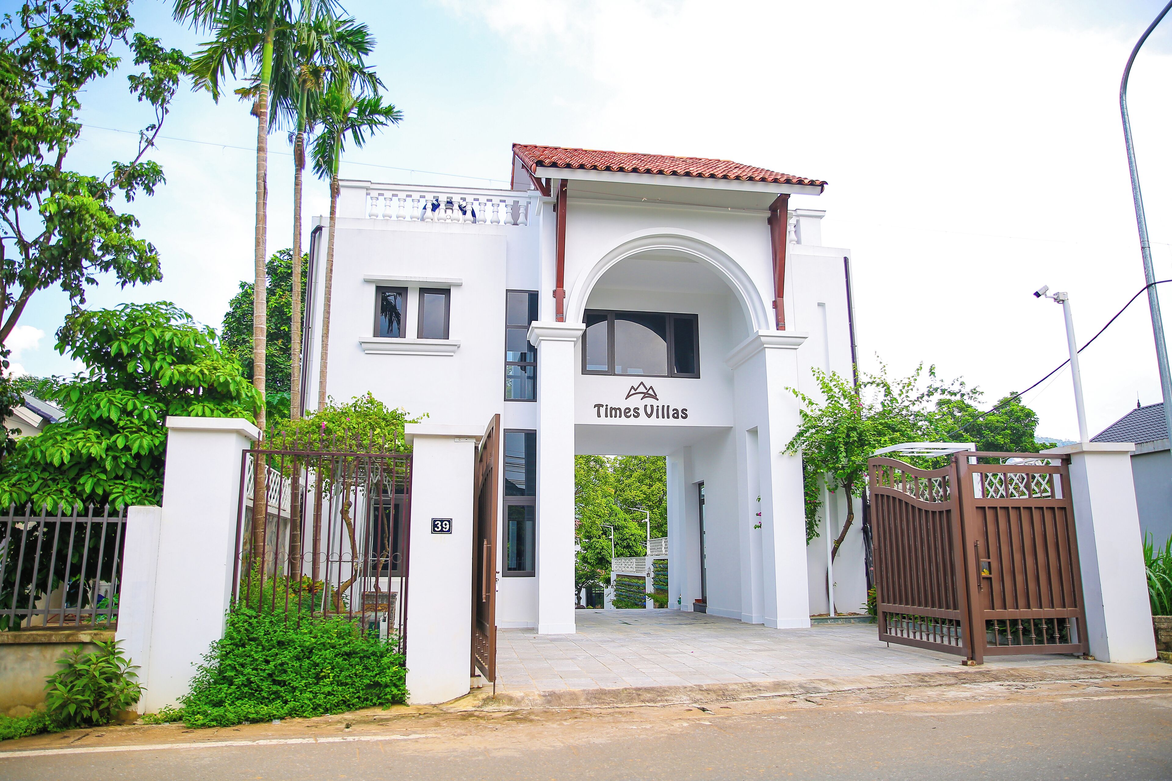 Uma entrada com portão para um edifício com uma placa que diz 'Times Villas'.