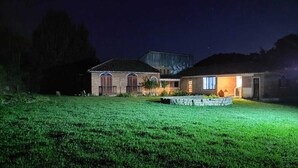 A house with a well-maintained lawn and a stone pathway leading to the entrance. - Maple Leaf Ecovillage Camping & Reserve (Resende)