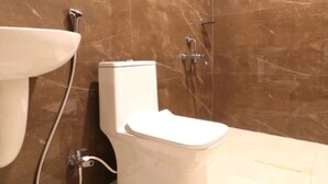 Un baño con inodoro, lavamanos y ducha.