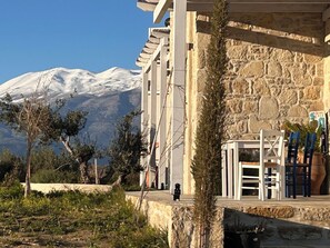 A building with stone walls and a view of a snow-capped mountain. - Quiet house in southern Crete, picturesque sea and mountain views, beach within walking distance (Pitsidia)
