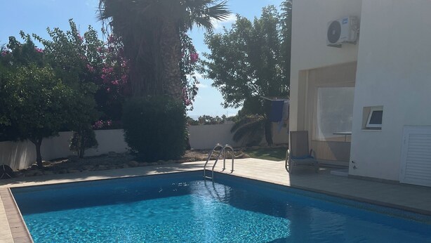 A rectangular swimming pool with clear blue water, surrounded by a tiled deck. - Ayia Thekla Villa Poppeli (Ayia Thekla)