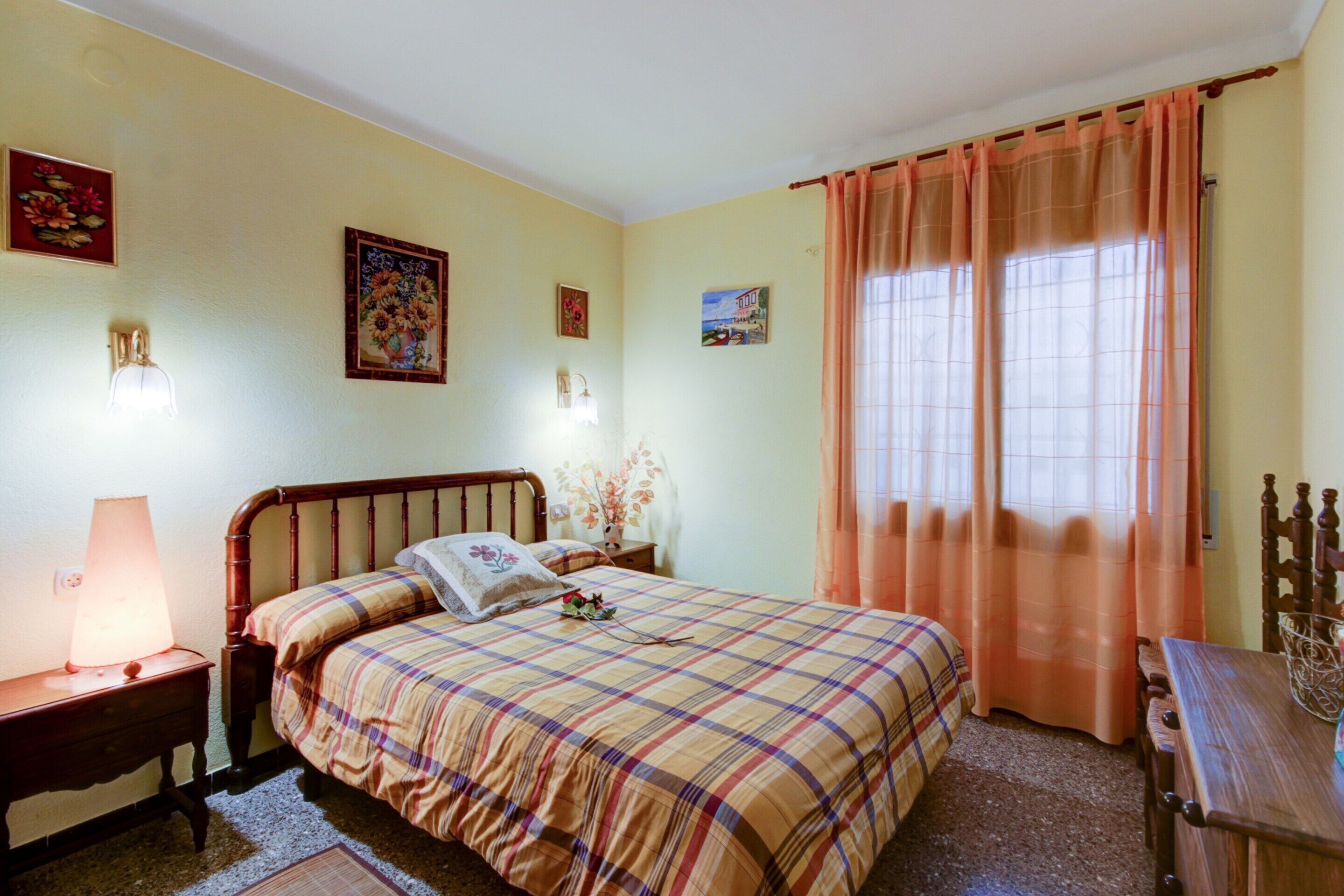 Una camera da letto con un letto, un comodino, una lampada e un tavolo di legno.