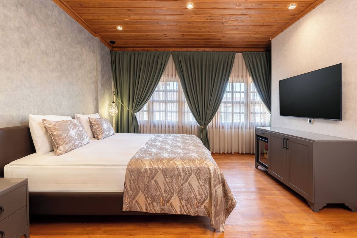 A bedroom with a bed, a TV, and a wardrobe.