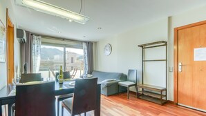 Ein modernes Zimmer mit Esstisch, Stühlen, einer Couch, einer Bank und einer Holztür.