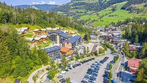 A mountainous town with a parking lot and buildings with multiple stories. - Apartment in Salzburg With Sunny Terrace (Wagrain)