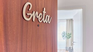 A wooden wall with the name "Greta" in a cursive font. - NEW Greta - Your home in the magical Black Forest (Baiersbronn)