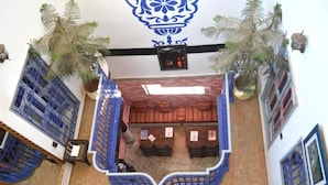 A lobby with a central seating area, a decorative ceiling, and potted plants. - Riad Wink (Marrakech)
