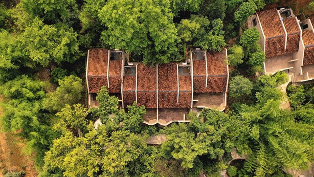 A large, rectangular building with multiple levels, surrounded by dense greenery. - Bandhav Vilas (Manpur)