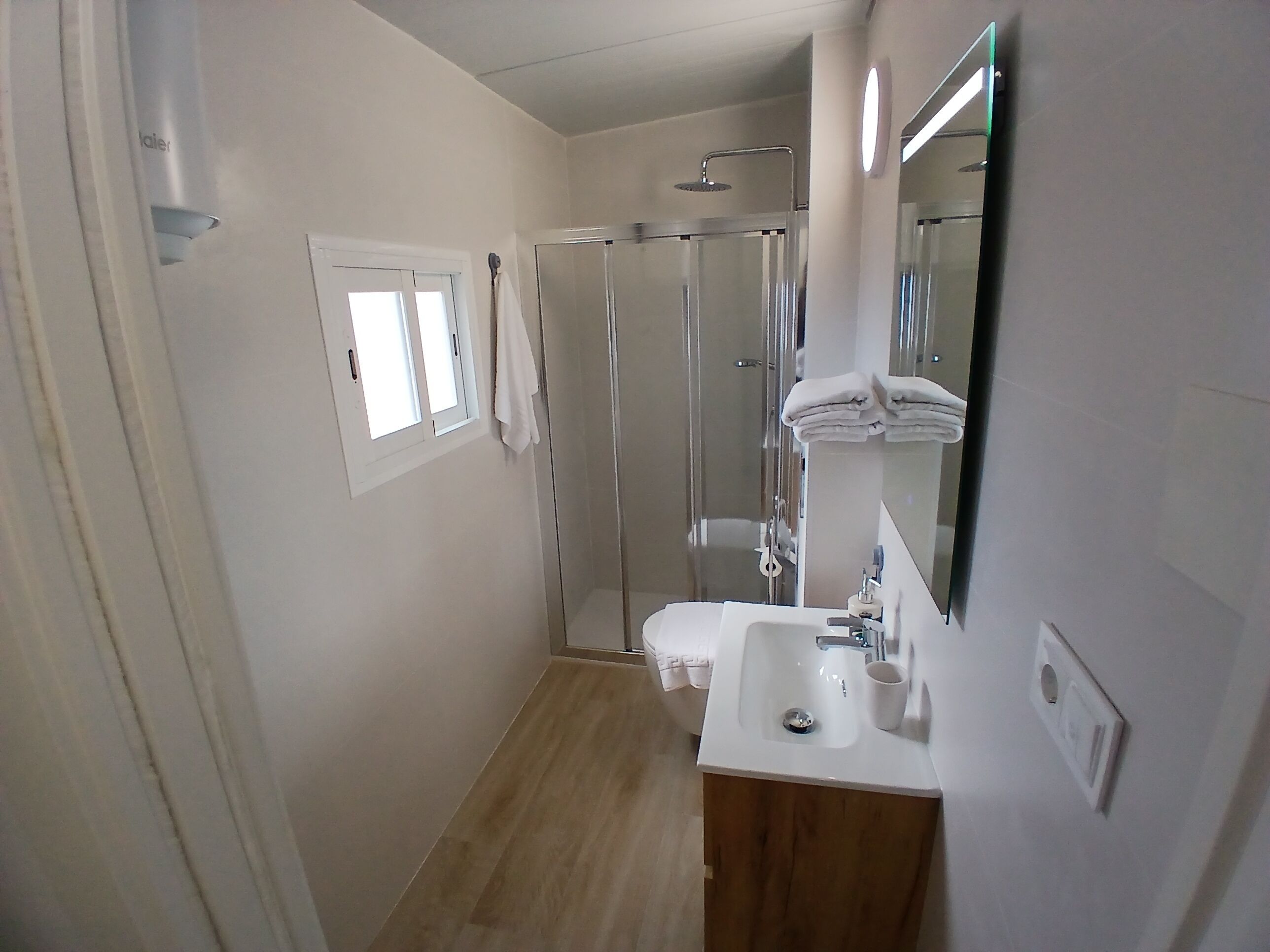 Un baño moderno con ducha, inodoro y lavamanos.