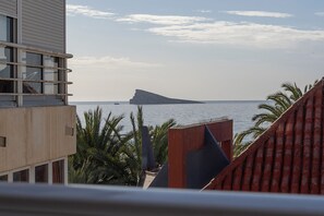 A coastal building with a view of the sea and a distant island. - Apartamentos Chorrol (Benidorm)