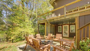 An outdoor patio with wooden furniture and a fire pit.
