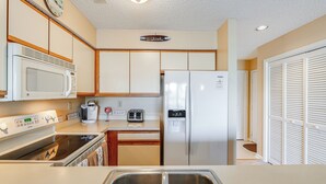 A kitchen with a microwave, stove, sink, toaster, and refrigerator. - Half Mi to Beach: Bayfront Ocean City Condo, Deck (Ocean City)