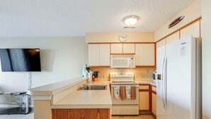 Una cocina compacta equipada con microondas, estufa, lavaplatos y refrigerador.
