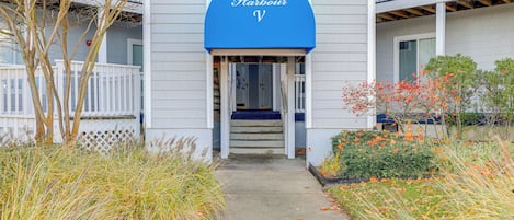 A building with a blue sign reading "Hidden Harbour" and a staircase leading to an entrance.