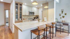 A modern kitchen with a large island, bar stools, and pendant lighting. - Kings Beach Retreat Near Lake Tahoe w/ Pool Access (Kings Beach)