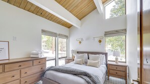 A bedroom with a large bed, wooden headboard, bedside tables with lamps, and a dresser. - Kings Beach Retreat Near Lake Tahoe w/ Pool Access (Kings Beach)