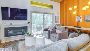 A modern living room with a fireplace, comfortable seating, and a large TV. - Kings Beach Retreat Near Lake Tahoe w/ Pool Access (Kings Beach)
