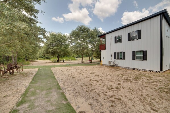 A modern building with a metal exterior, a paved driveway, and a well-maintained lawn.
