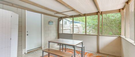 Une pièce avec un plafond en bois, une porte blanche, un banc et un tapis à motifs.