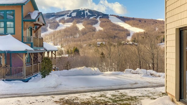 A house with a porch and a view of a snow-covered mountain. - Snow Mountain Condo: Hot Tub + Shuttle to Resort (West Dover)