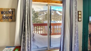 A room with a view of a snowy mountain, a wooden sign reading "MOUNT SNOW", and a wooden floor. - Snow Mountain Condo: Hot Tub + Shuttle to Resort (West Dover)