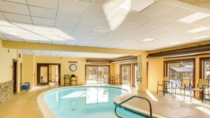 A pool area with a clock, chairs, and tables. - Snow Mountain Condo: Hot Tub + Shuttle to Resort (West Dover)