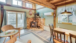 Una habitación acogedora con chimenea, muebles de mimbre y una mesa de comedor.