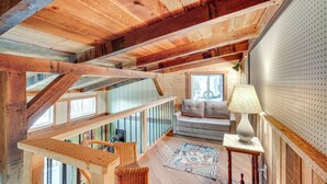 Interior de madera con una escalera, un sofá, una lámpara y una alfombra.