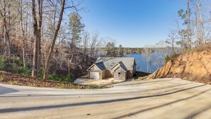 A house with a garage, a driveway, and a lake in the background.