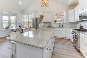 A spacious kitchen with white cabinetry, a granite countertop, and a large island. - Private Lakeview Haven in Rockford (Rockford)
